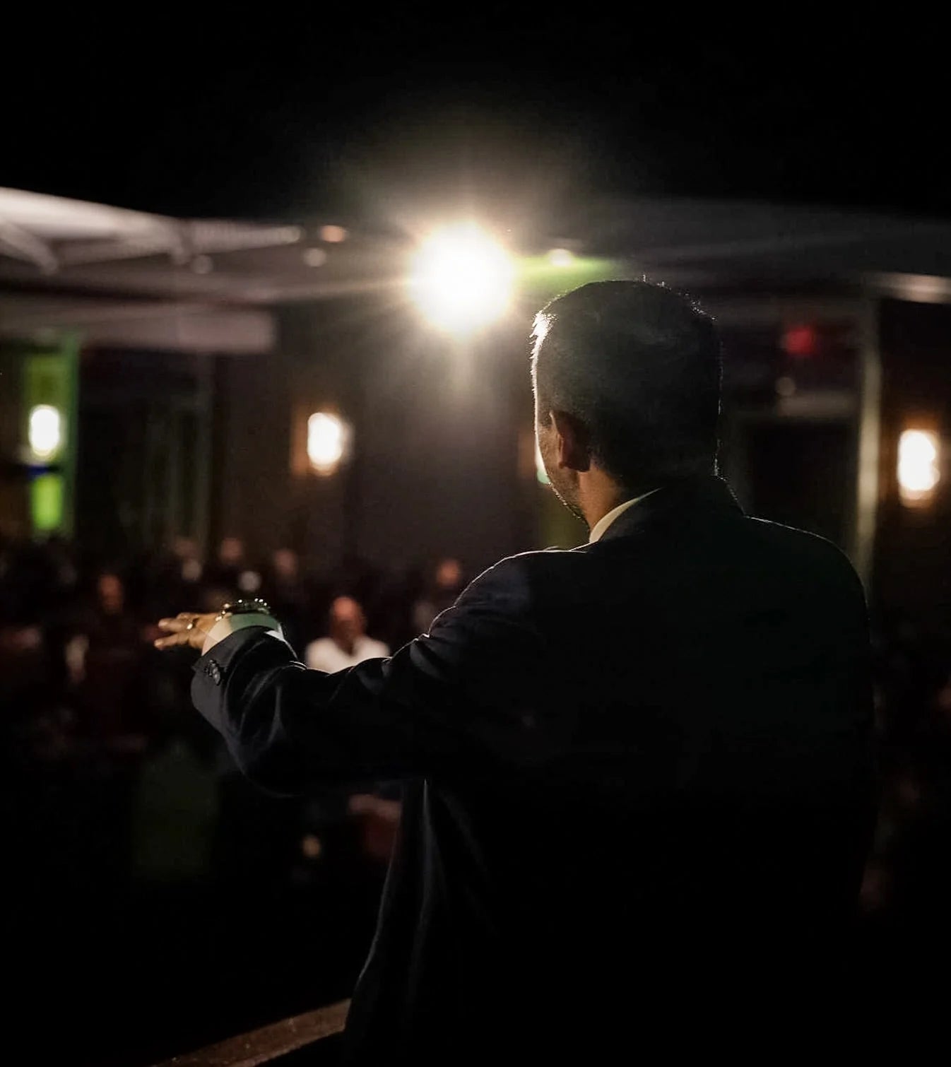 A speaker in the spotlight addressing the room
